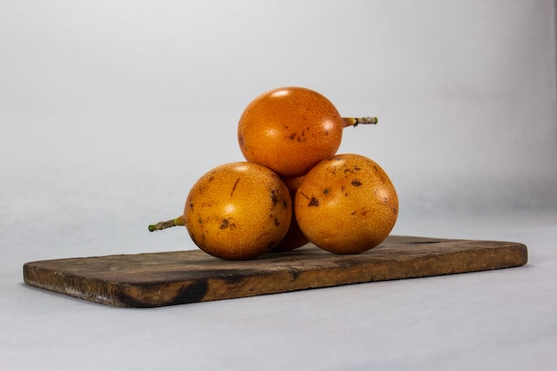 grenadille trois fruits péruviens à peau dure sur une assiette en porcelaine et planche de bois