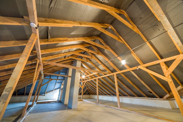 Grenier d'un immeuble avec poutres en bois d'une structure de toit.