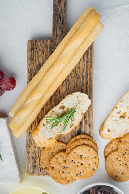 Gressins, avec de l'huile d'olive, sur table blanche, mise à plat