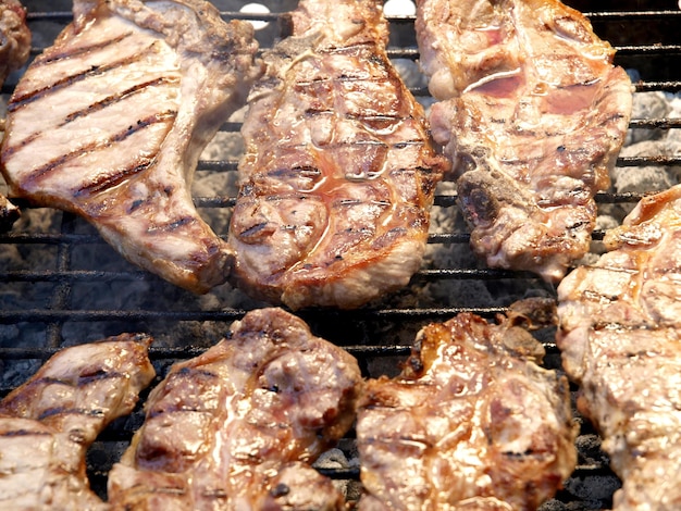 Un gril avec de la viande dessus et le mot " bbq " sur le dessus.