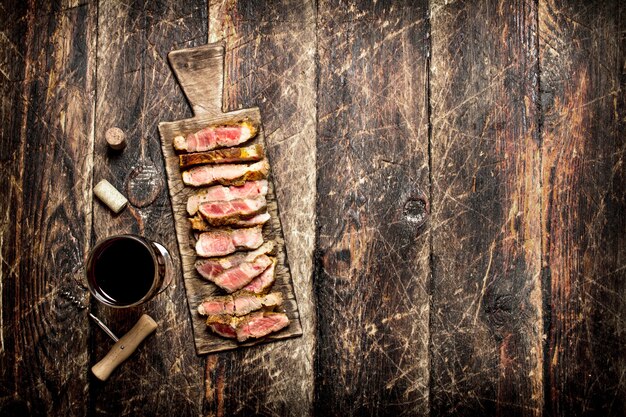 Gril à viande. Morceaux de porc grillés aux épices et au vin rouge sur la vieille table en bois.