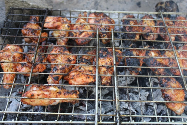 Un grill avec des ailes de poulet dessus