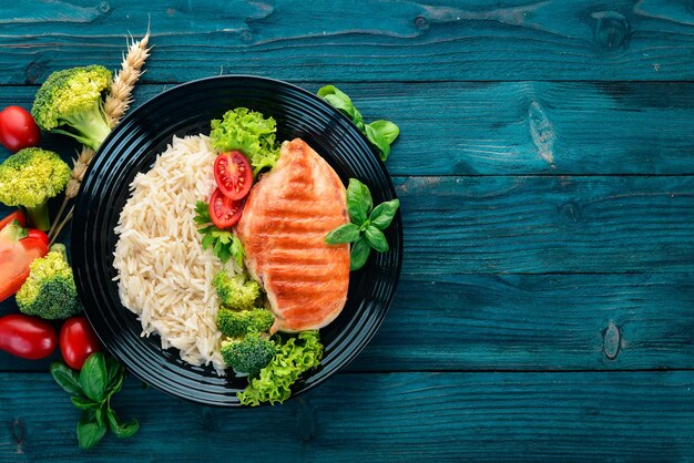 Grill de poitrine de poulet avec riz et légumes Alimentation saine Sur une table en bois bleue Vue de dessus Espace libre pour le texte