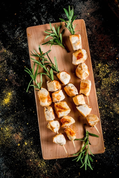 Grill, viande de barbecue. Brochettes de poulet au romarin. Sur un métal rouillé noir, vue de dessus