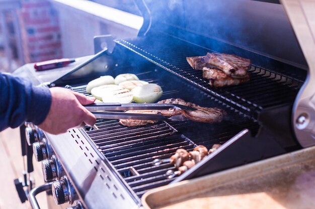 Griller des côtelettes de porc sur un gril à gaz en été.