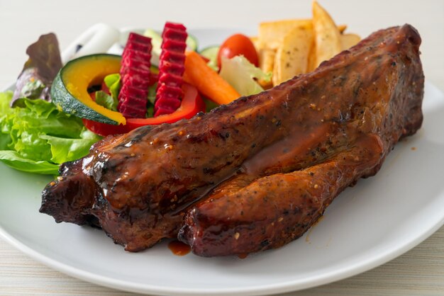 griller des côtes levées de porc au barbecue avec des légumes