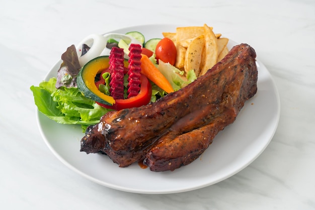 griller des côtes levées de porc au barbecue avec des légumes