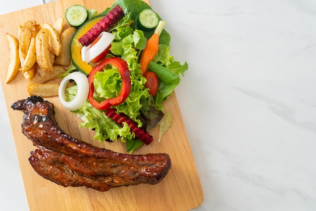 griller des côtes levées de porc au barbecue avec des légumes