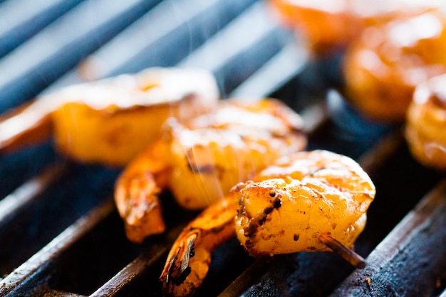 Griller des crevettes fraîches sur des brochettes.