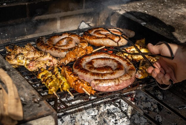 Griller le détail de la nourriture d'un barbecue avec des brochettes de saucisses et de poulet par une journée ensoleillée