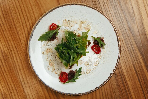 Griller le fromage à la crème et la roquette à la tomate sur la vue de dessus de fond en bois