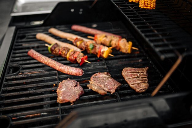 Griller des saucisses et des brochettes sur un barbecue