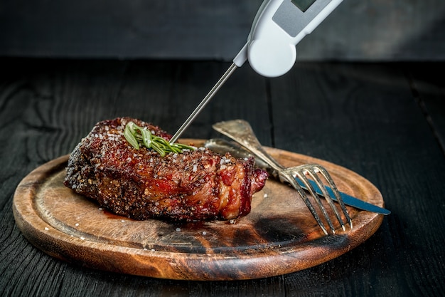 Griller un steak de bœuf juteux avec du sel, du poivre et du romarin