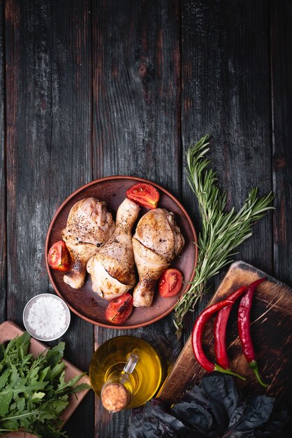 Griller la viande, les cuisses de poulet se trouvent sur une assiette, des épices délicieuses et aromatiques