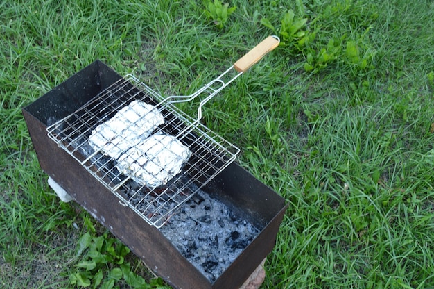 Griller avec de la viande et des légumes en papillote est sur le gril Cuisiner sur un pique-nique