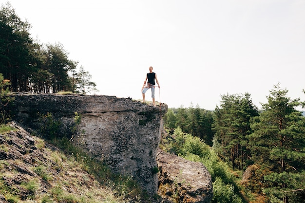 Grimpeur debout au bord de la falaise avec une corde