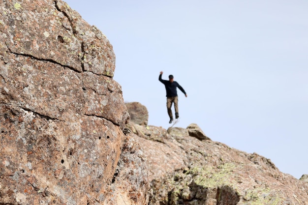 Un grimpeur sautant d'un rocher haut dans les montagnes