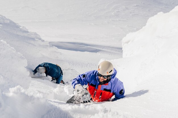 Les grimpeurs sortent d'une congère dans les montagnes