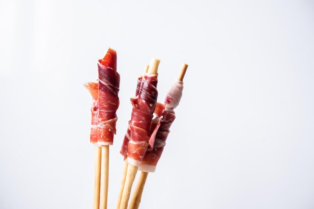 Grissini au jambon ibérique de glands sur fond blanc Tapa espagnol pour des événements ou des célébrations