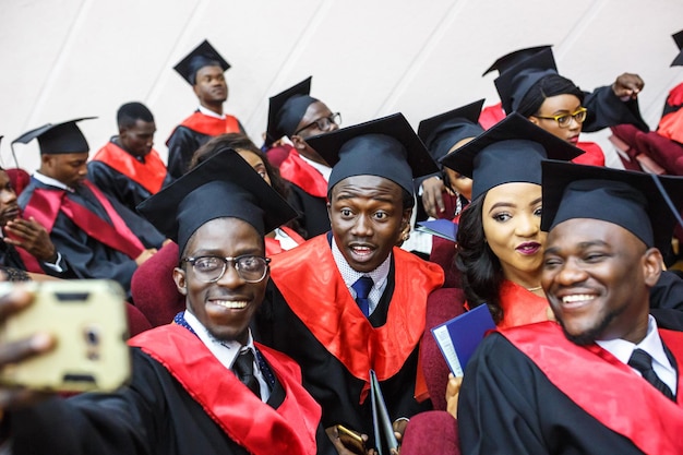 GRODNO BÉLARUS JUIN 2018 Étudiants en médecine africains étrangers dans des casquettes de graduation académiques carrées et des imperméables noirs pendant le début des diplômes