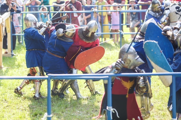 GRODNO BÉLARUS JUIN 2019 groupe de combats de chevaliers médiévaux en armure casques cotte de mailles avec haches et épées sur les listes reconstruction historique de l'ancien combat