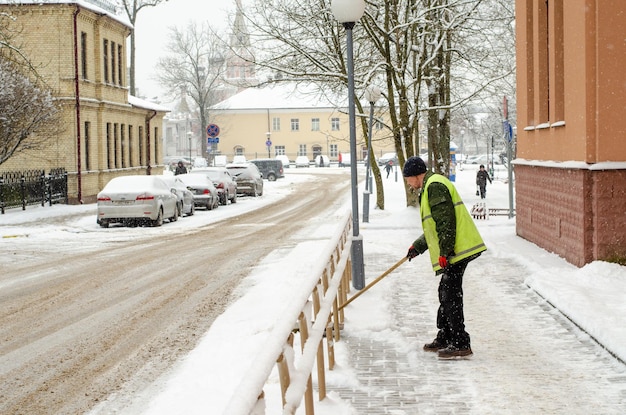 Grodno Bélarus 11 janvier 2019 Tempête de neige dans la ville Routes et trottoirs recouverts de neige Pelle de travailleur efface la neige Mauvais temps hivernal Nettoyage des rues après la tempête de neige