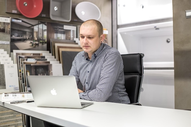 GRODNO BELARUS MARS 2019 jeunes employés travaillent à l'ordinateur dans un magasin de plomberie de luxe moderne