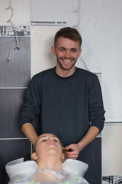 Grodno, Biélorussie - 20 octobre 2016 : Artem Raychuk, technologue de la marque Keune, teint les cheveux d'un modèle lors d'un atelier publicitaire avec la participation au salon de beauté Kolibri.