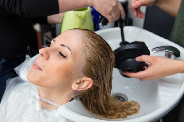 Grodno, Biélorussie - 20 octobre 2016 : Les participants au séminaire teignent les cheveux d'un modèle sur l'atelier publicitaire de la marque Keune dans le salon de beauté Kolibri.