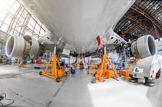 Un gros aéronef pour la maintenance de service sur des vérins spéciaux dans le hangar.