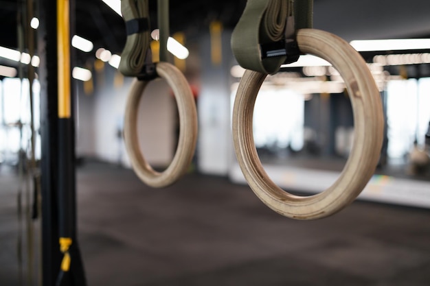Gros anneaux de gymnastique suspendus dans une salle de sport.