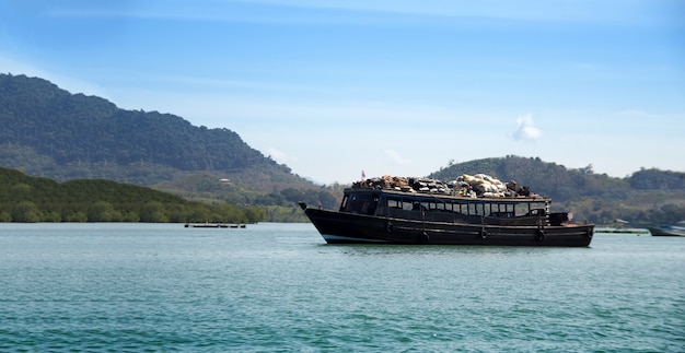 Un gros bateau transporte des marchandises à travers l'île