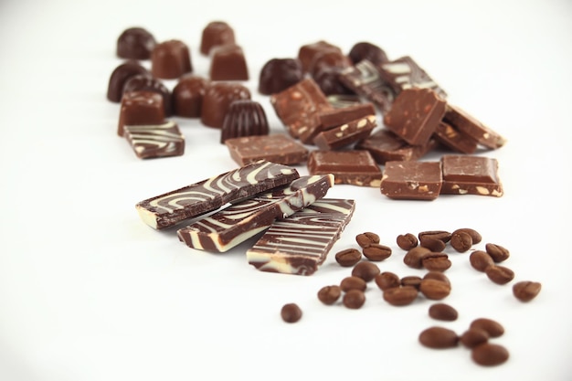Gros bouleversement de barres de chocolat et de grains de café isolés sur whitephoto with copy space