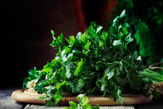 Gros bouquet de persil italien vert sur la table mise au point sélective de fond en bois vintage