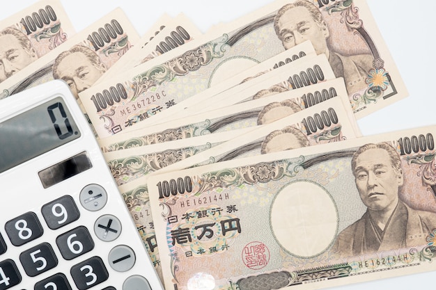 Gros calculateur sur billet de banque en monnaie japonaise yen argent. économie du japon.