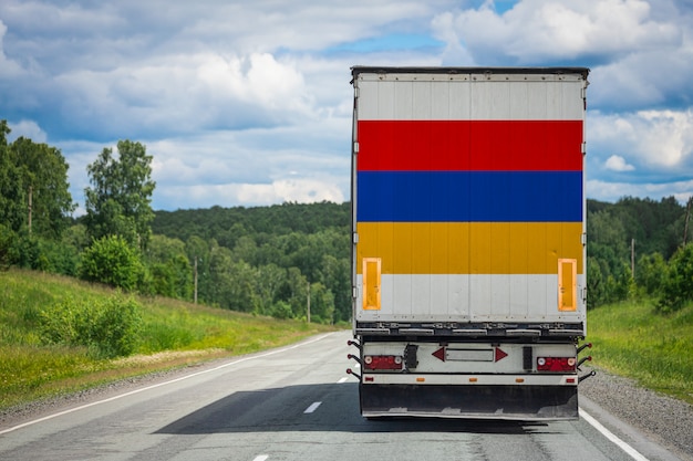 Gros camion avec le drapeau national de l'Arménie se déplaçant sur l'autoroute