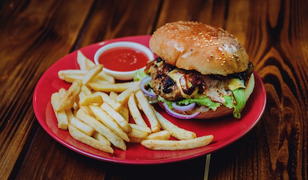 Gros cheeseburger et chips sur une plaque.