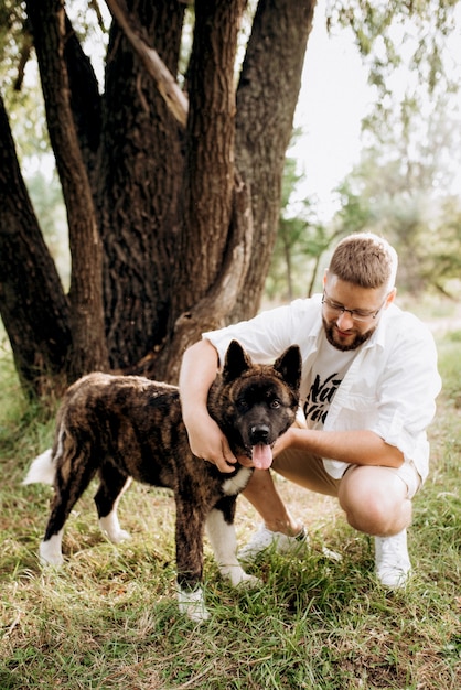 Gros chien pour une promenade avec un gars et une fille dans la prairie verte