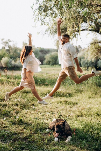 Gros chien pour une promenade avec un gars et une fille dans la prairie verte