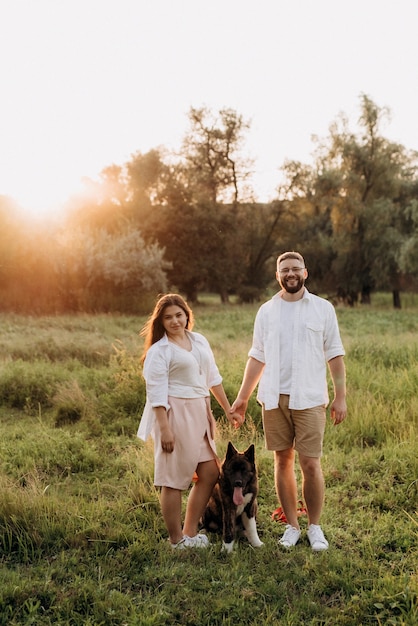 Gros chien pour une promenade avec un gars et une fille dans la prairie verte