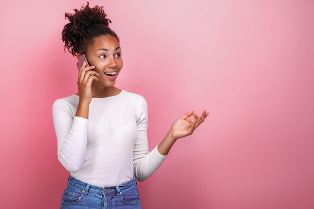 Photo gros femme youngmulatto parlant sur son téléphone portable avec une expression faciale heureuse.