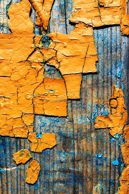 Gros fragments de vieille peinture écaillée couleur ocre sur une vieille surface en bois
