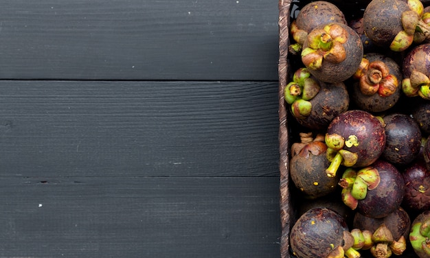 Gros fruit de mangoustan sur bois noir