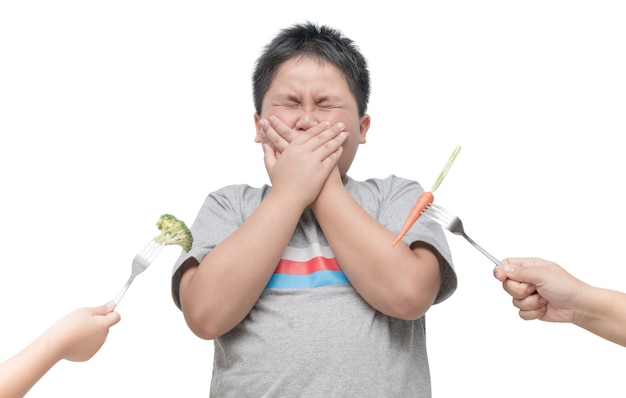 Gros garçon obèse avec une expression de dégoût contre les légumes isolés sur fond blanc, Refusant f