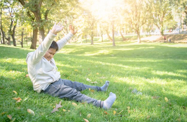 Gros garçon s&#39;étirer dans parc