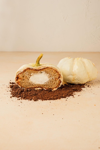 Gros gâteau en forme de citrouille coupée en deux pour montrer la garniture pour Halloween