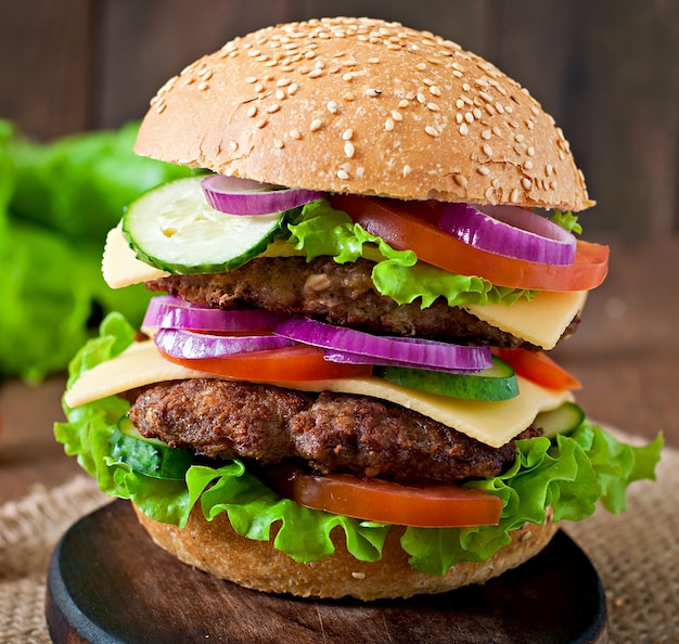 Gros hamburger juteux avec légumes et boeuf sur une table en bois de style rustique