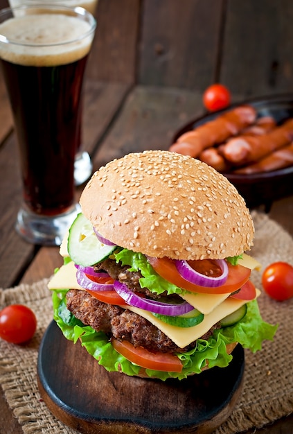 Gros hamburger juteux avec légumes et boeuf sur une table en bois de style rustique