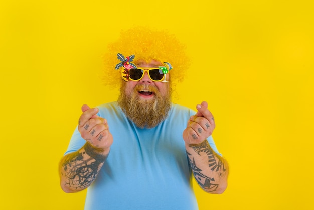 Gros homme avec perruque en tête et lunettes de soleil demande de l'argent