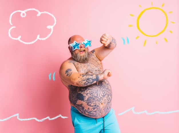 Gros homme avec des tatouages de barbe et des lunettes de soleil danse la musique